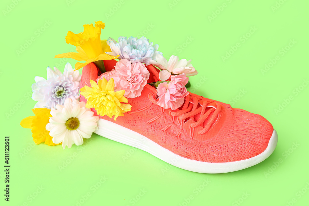 Sneaker with spring flowers on green background