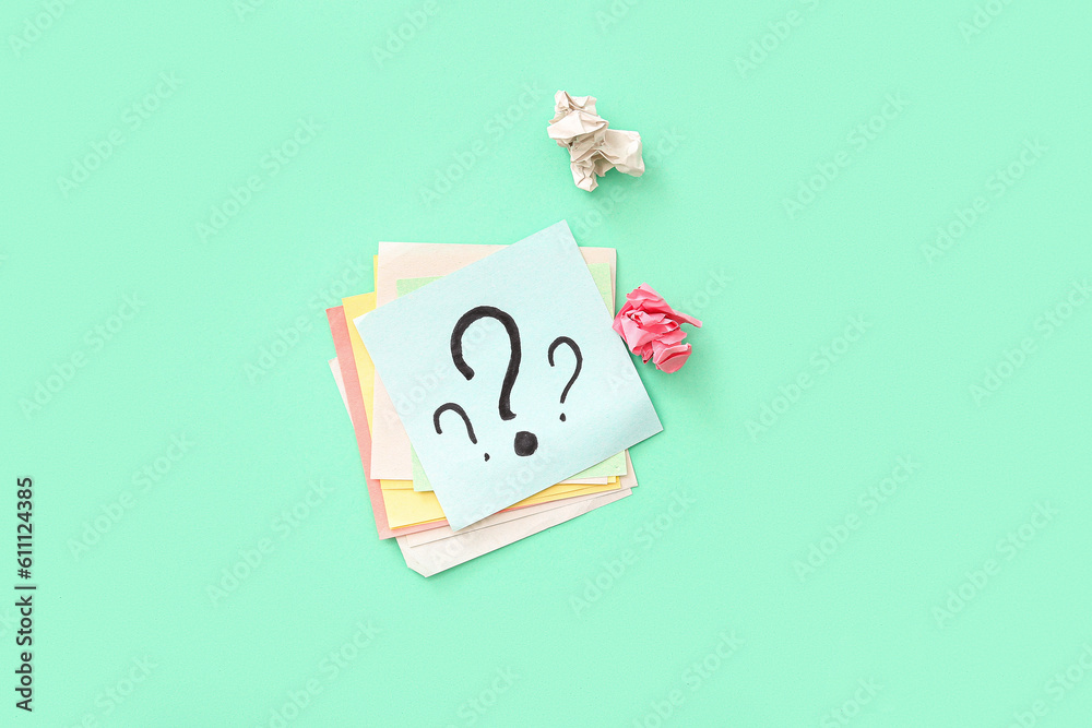 Sticky notes with question marks and crumpled paper on green background