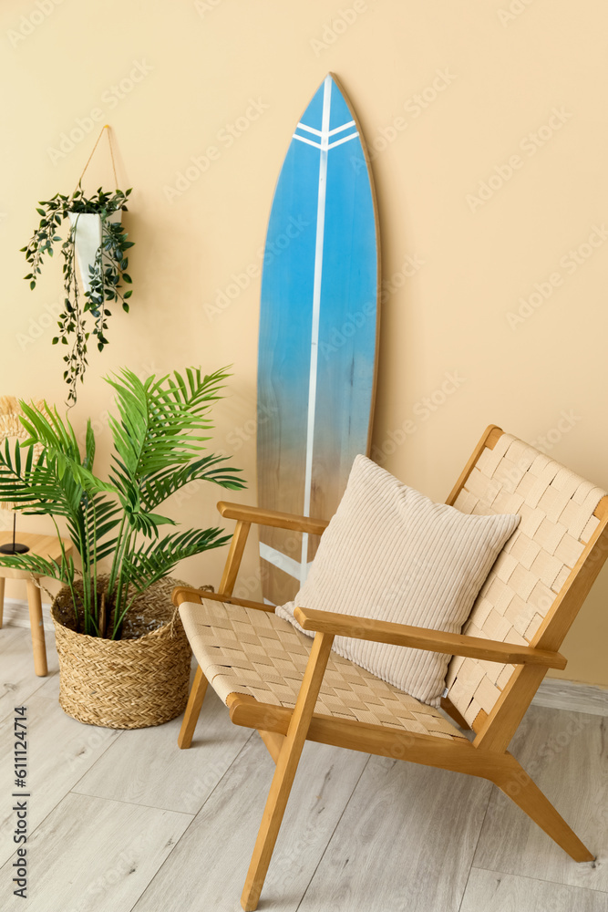 Interior of living room with surfboard, armchair and houseplants