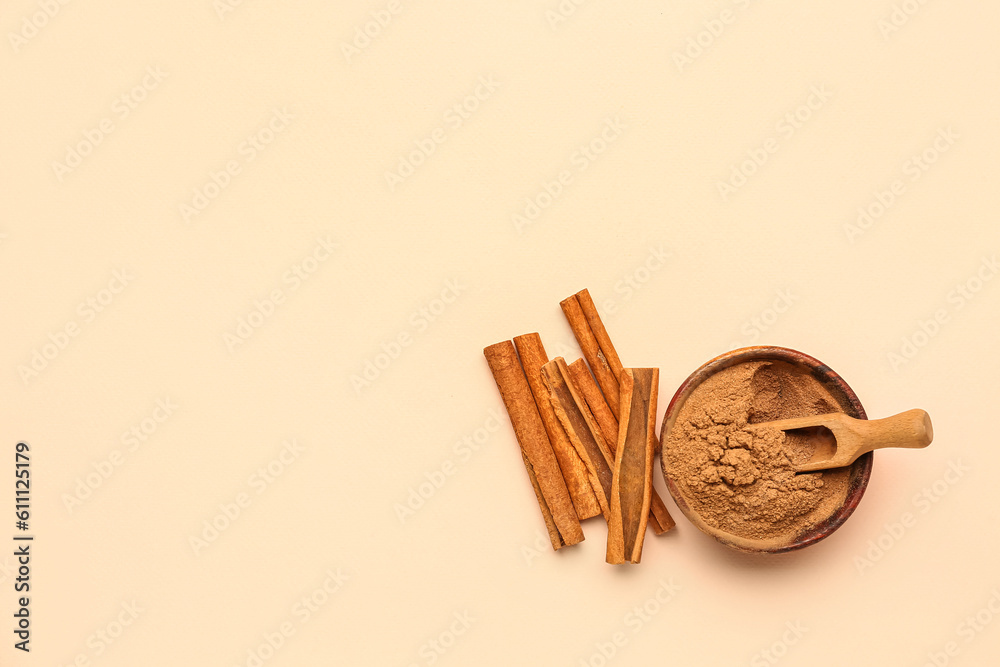 Bowl of cinnamon powder and sticks on color background