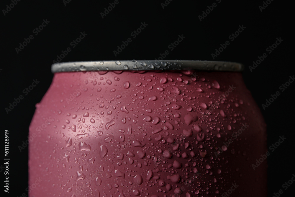 Pink can of fresh soda with water drops on dark background, closeup