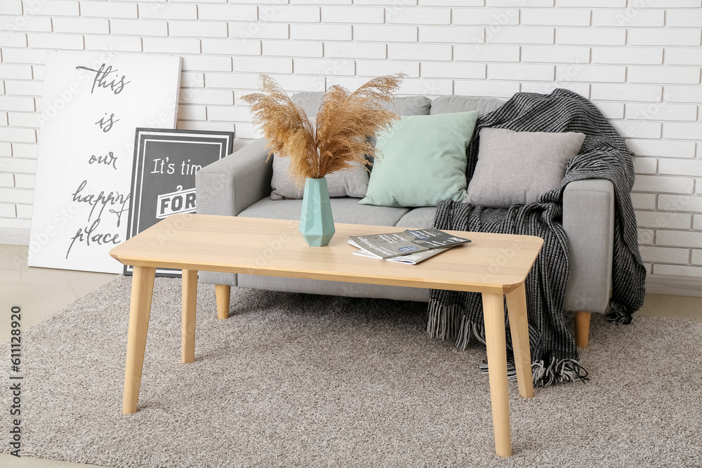 Interior of living room with sofa and vase on table