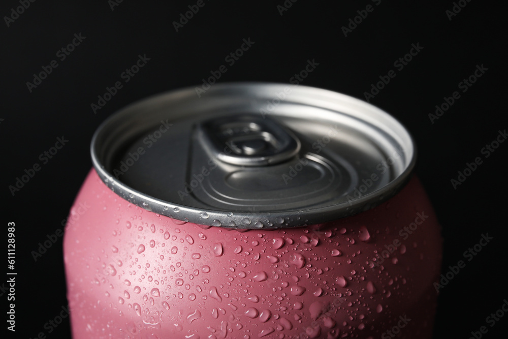 Pink can of fresh soda with water drops on dark background, closeup