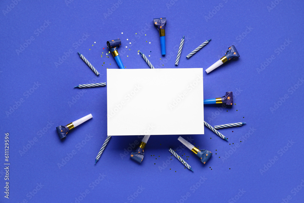 Frame made of different party decor with greeting card on dark blue background