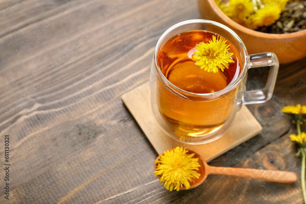 Bowl and glass cup of healthy dandelion tea on wooden background