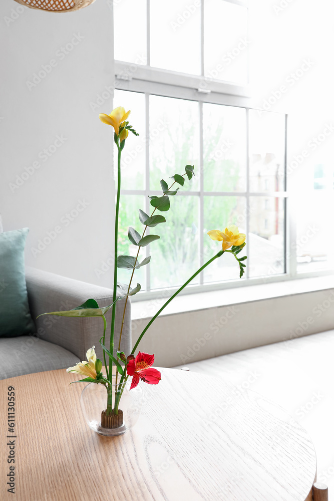 Beautiful ikebana on coffee table in living room