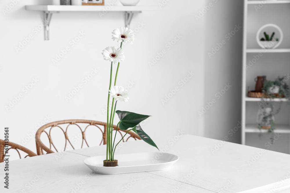 Beautiful ikebana on dining table in room