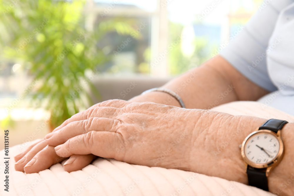 Senior woman with pillow sitting at home, closeup