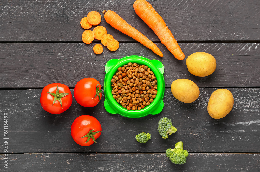 Composition with dry pet food and natural products on dark wooden background