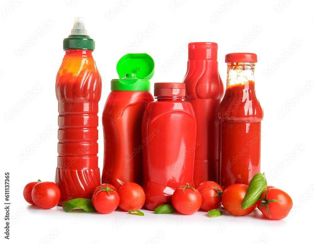 Bottles of ketchup and tomatoes on white background