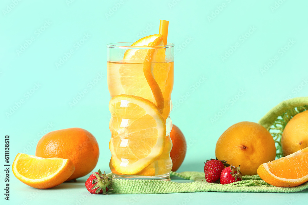 Glass of infused water with orange slices on blue background