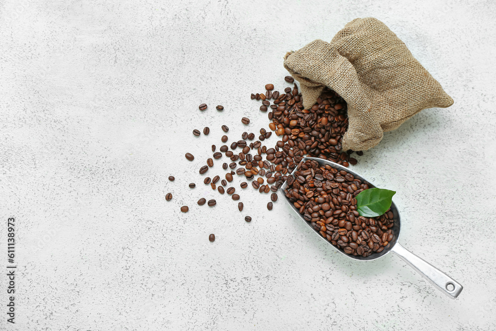 Sack bag and scoop with coffee beans on light background