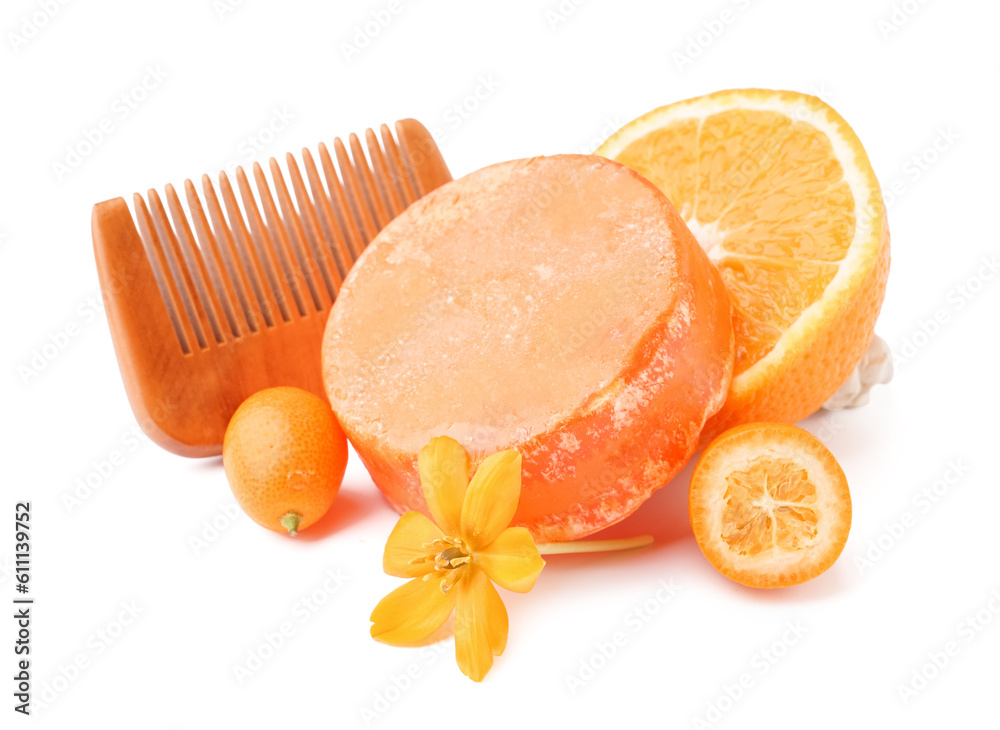 Solid shampoo bar with oranges, kumquat and comb on white background