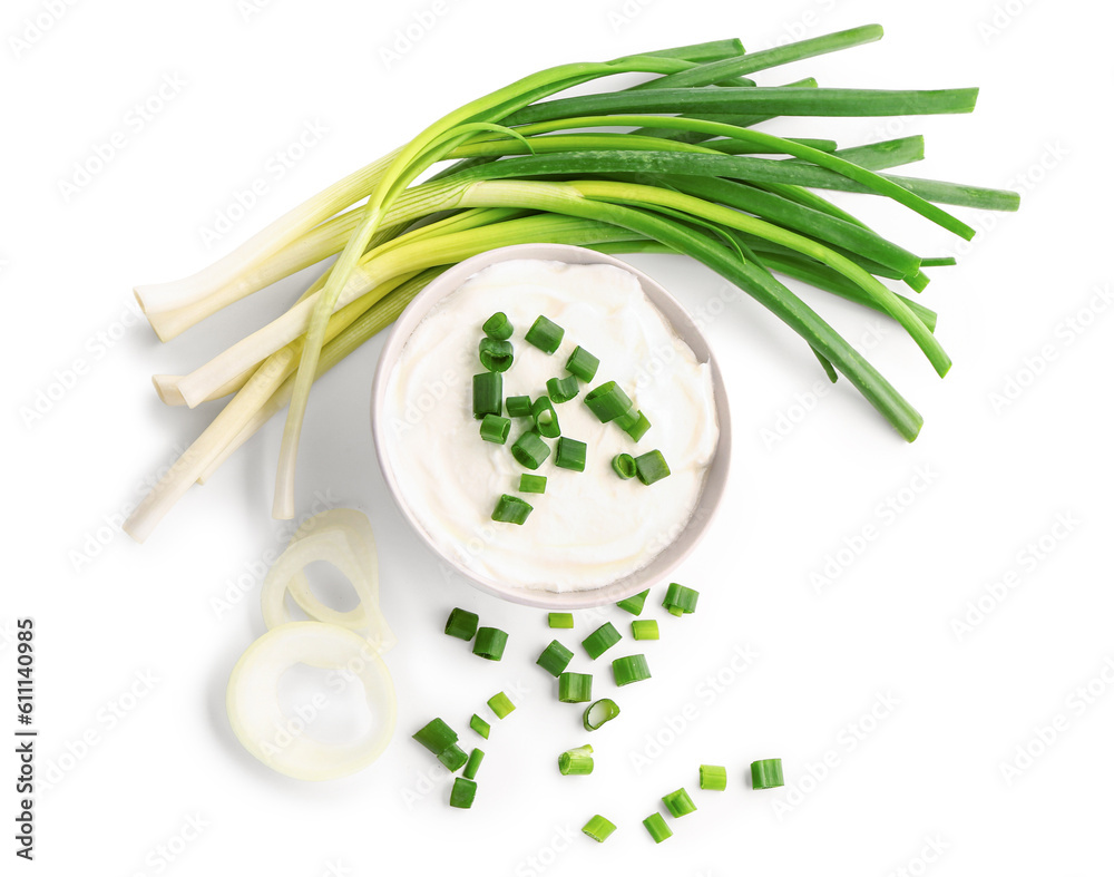 Bowl of tasty sour cream with sliced scallion and onion on white background