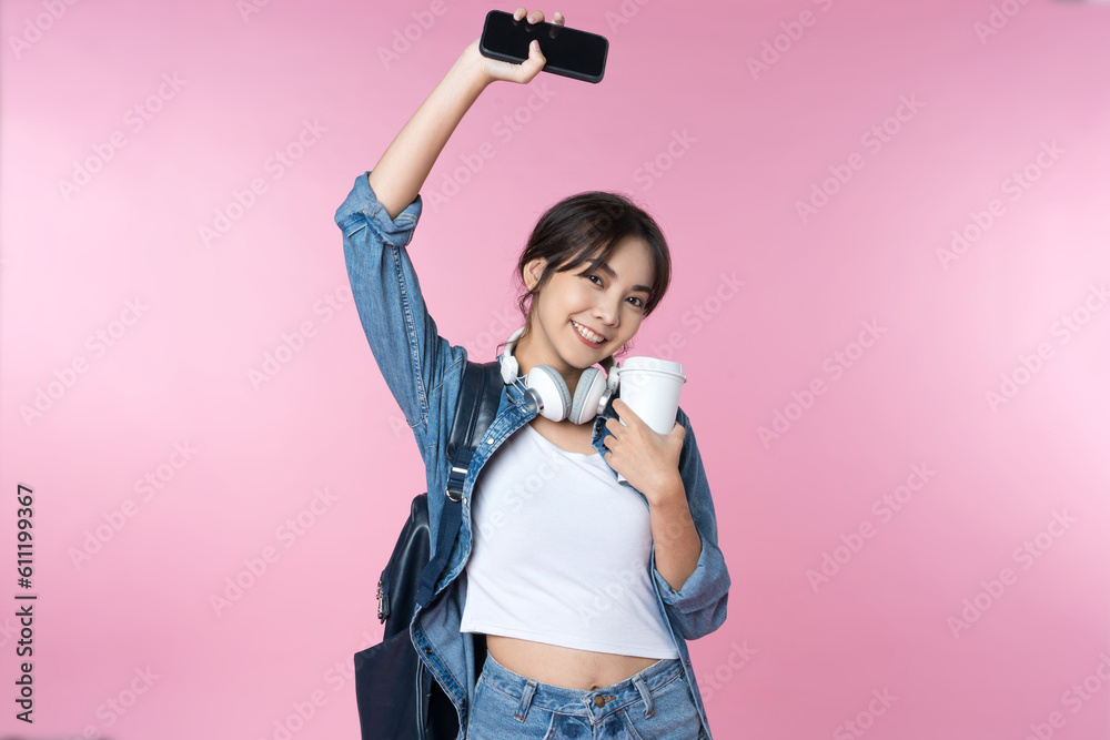 Portrait of young Asian woman student standing with smartphone coffee and backpack.College Teenager 