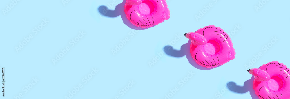 Summer concept with pink flamingo floats - flat lay