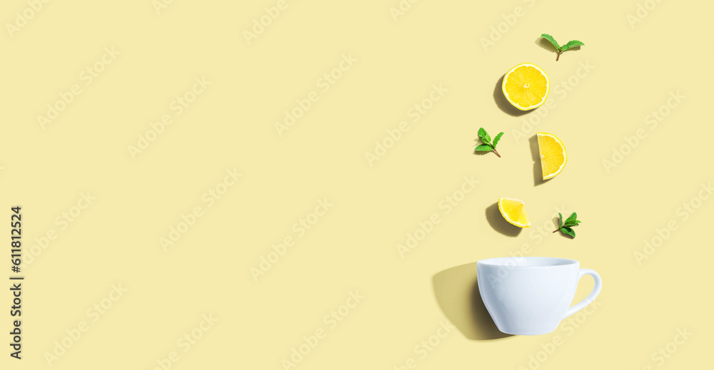 Fresh yellow lemons with tea cup overhead view - flat lay