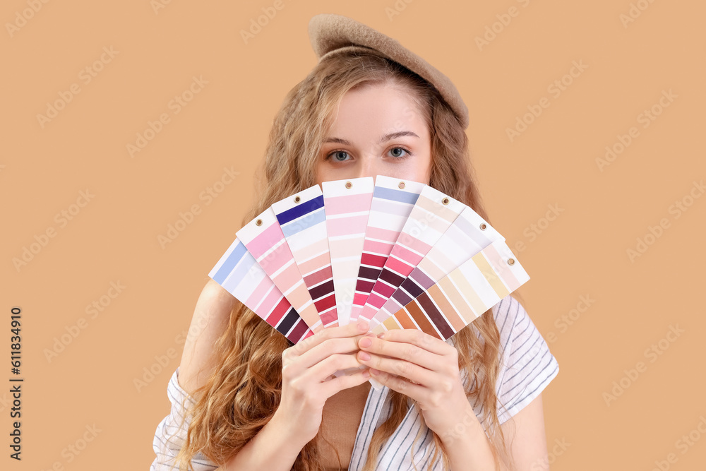 Female artist with paint color palettes on beige background