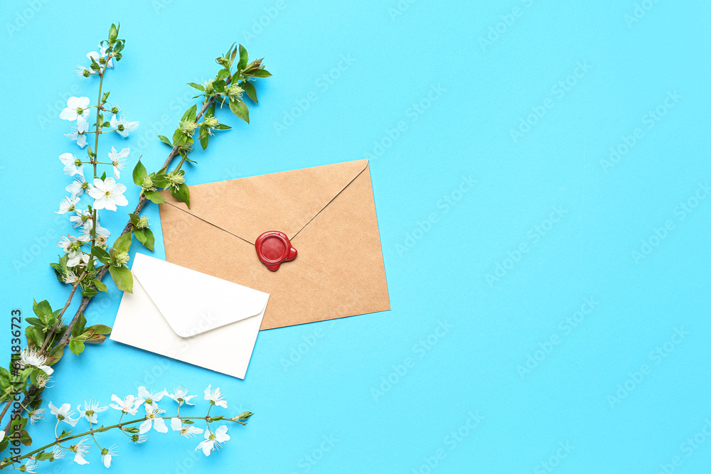 Blooming tree branches with white flowers and envelopes on blue background