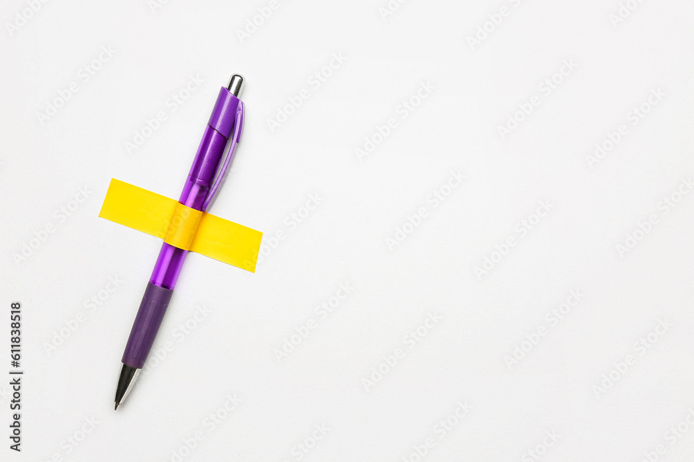 Pen with adhesive tape on light background