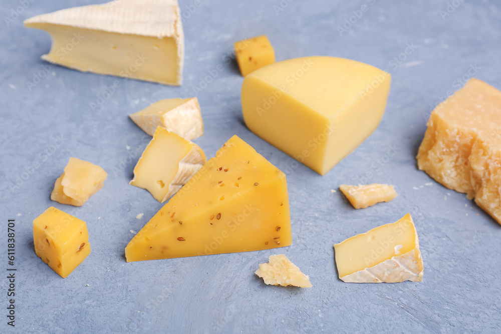 Pieces of tasty cheese on grey background