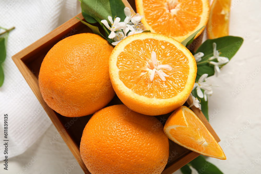 Wooden box of oranges with blooming branch as background