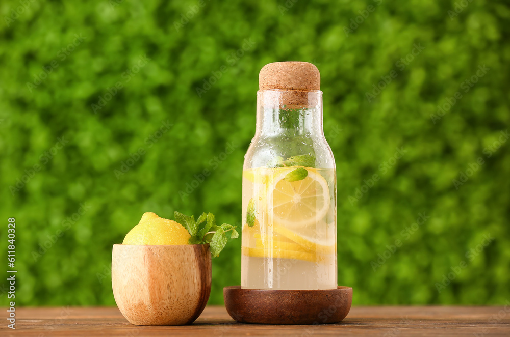 Bottle with fresh lemonade on wooden table