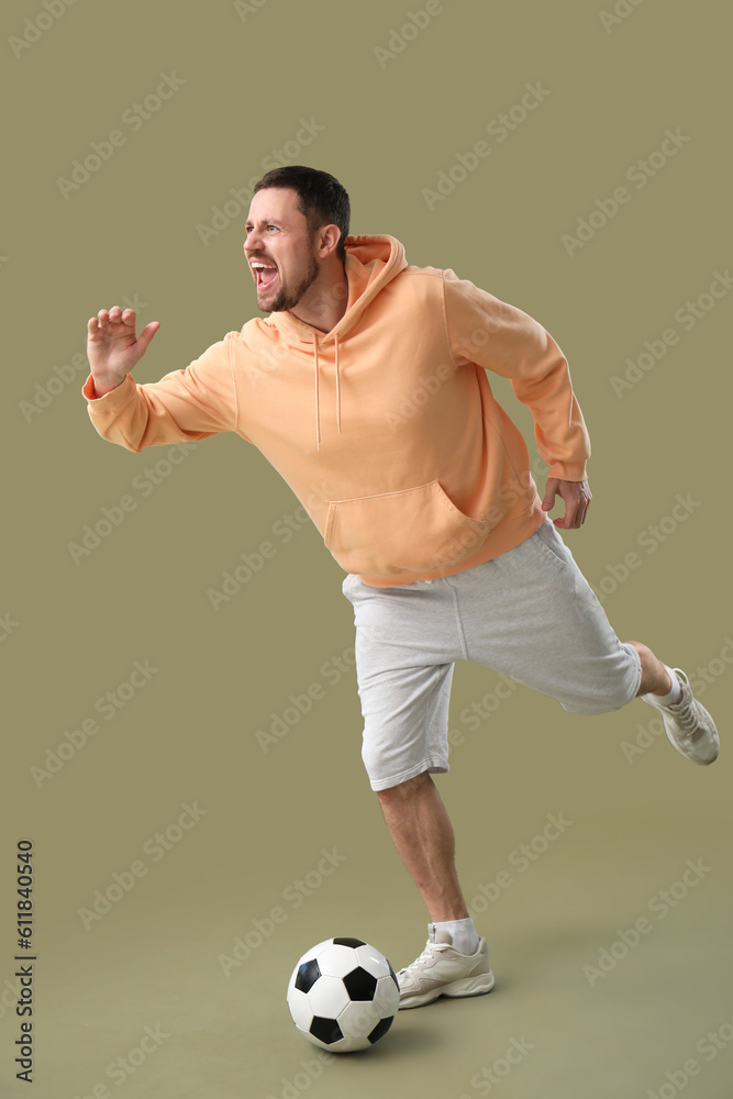 Man playing with soccer ball on color background