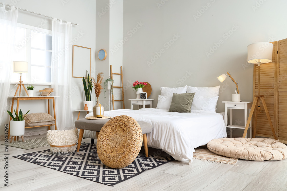 Interior of light bedroom with soft bench and tables