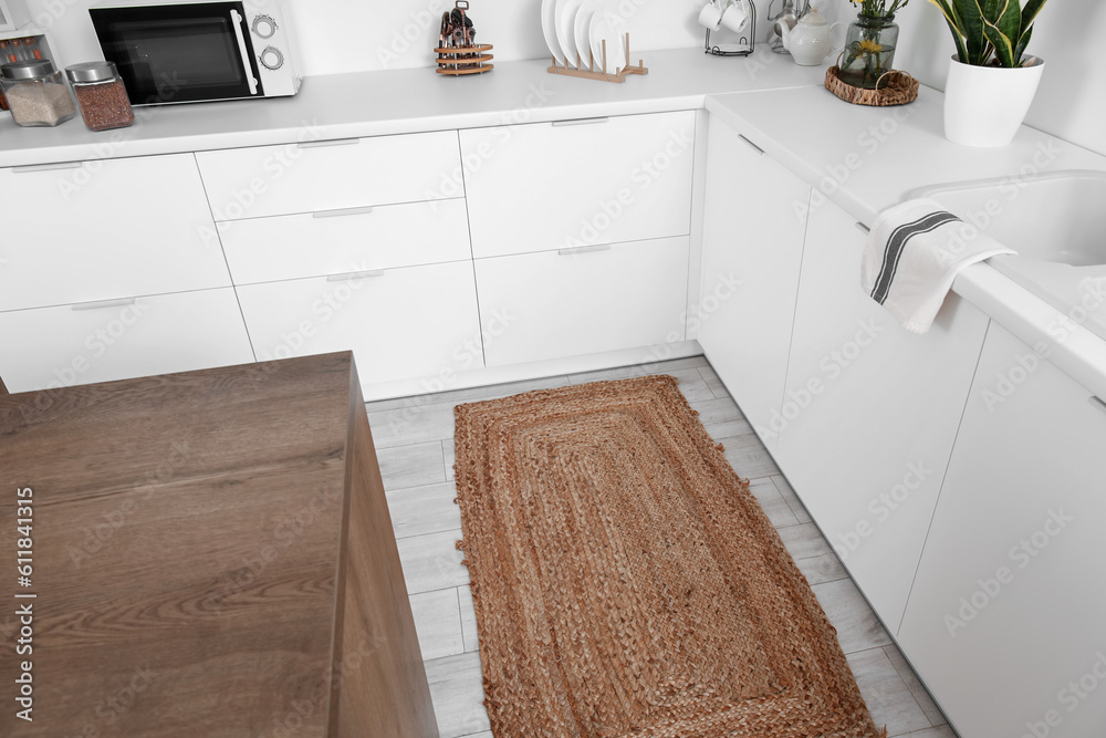 Wicker rug on floor in light kitchen