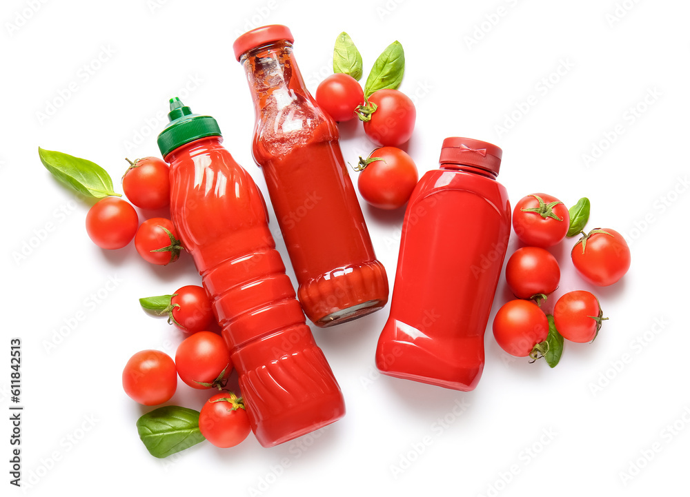 Bottles of ketchup and tomatoes on white background