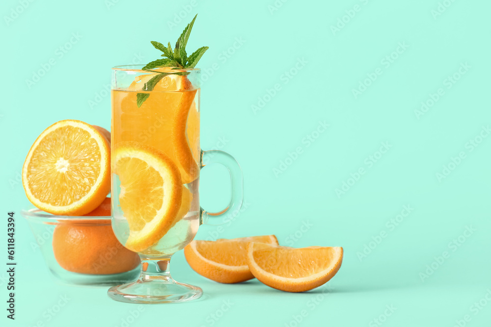 Glass of infused water with orange slices on blue background