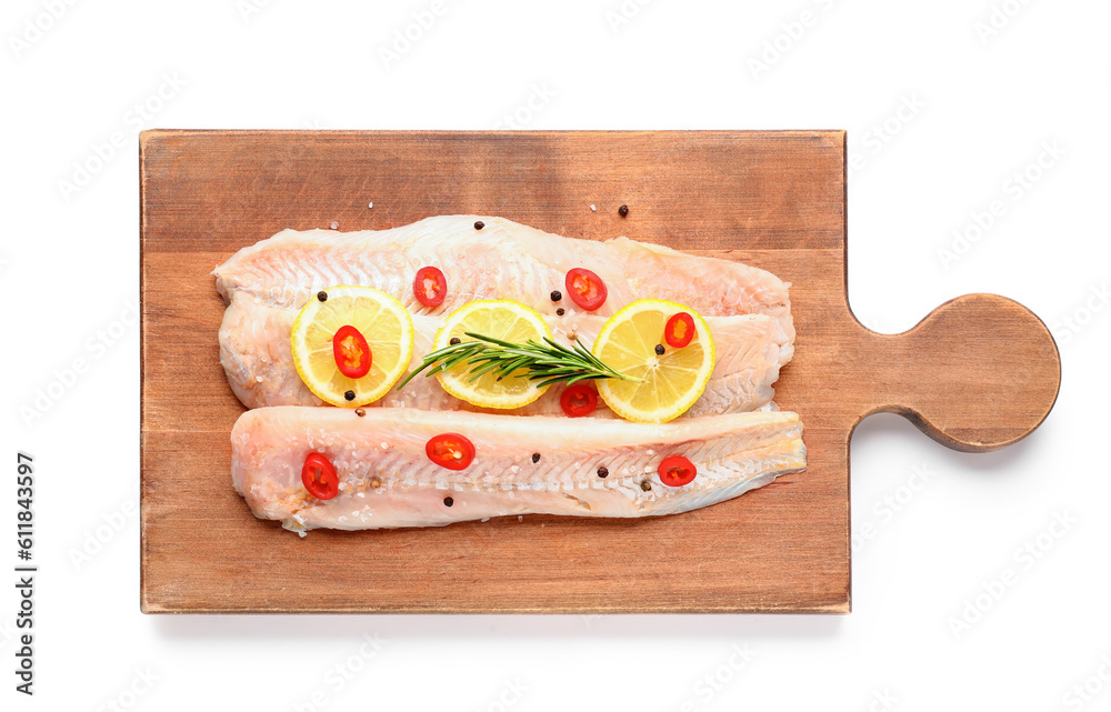 Wooden board of raw cod fillet with lemon on white background