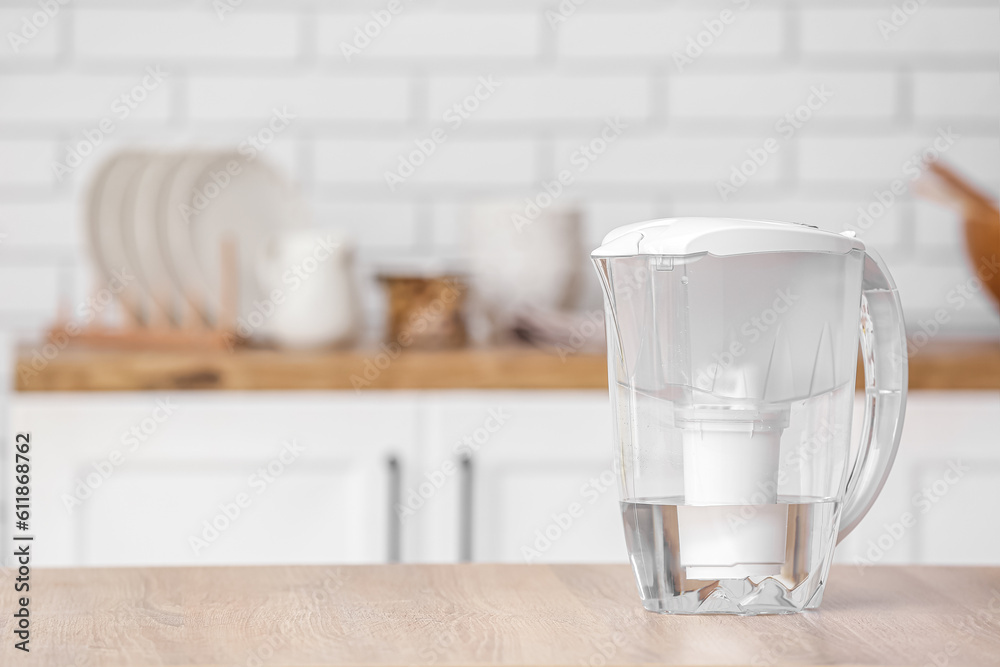 Water filter jug on table in modern kitchen