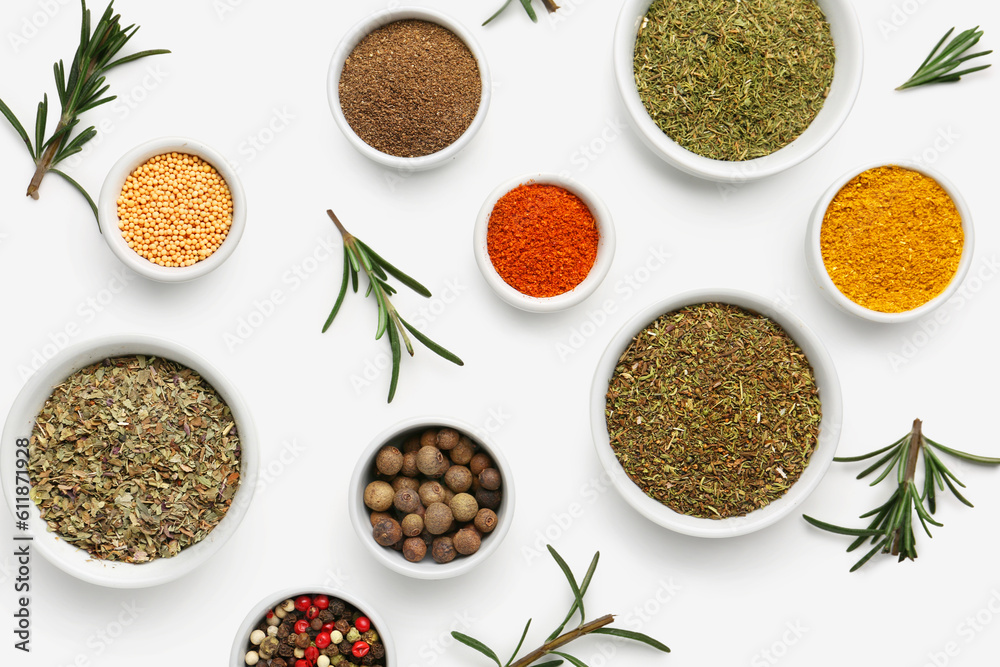 Composition with bowls of different spices and rosemary on light background