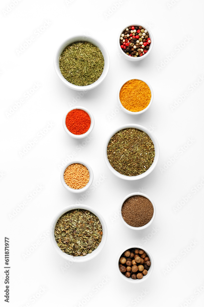 Composition with bowls of different aromatic spices on light background