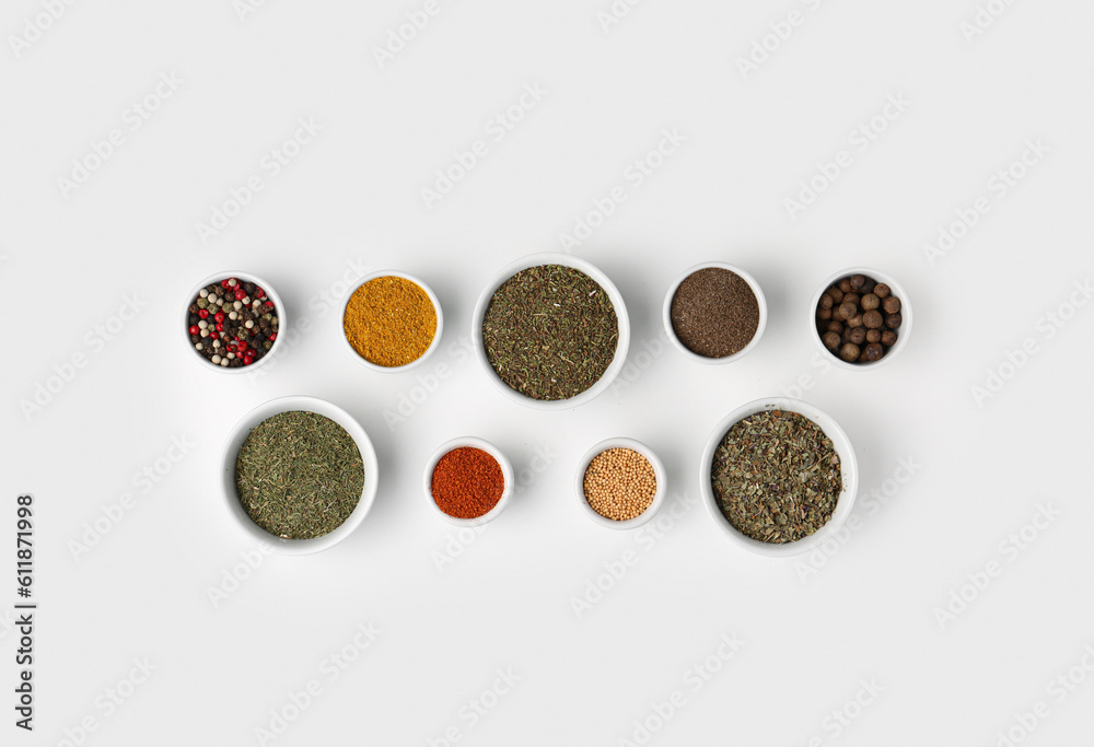 Composition with bowls of different aromatic spices on light background