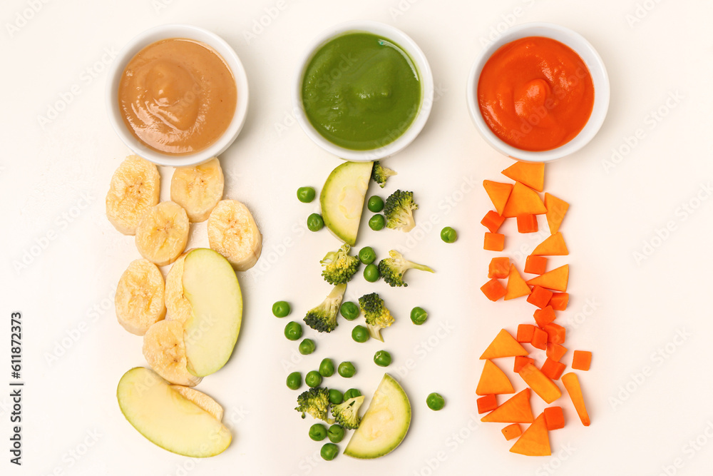 Composition with bowls of healthy baby puree and ingredients on white background