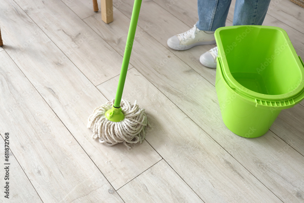 Housewife mopping floor in kitchen, closeup