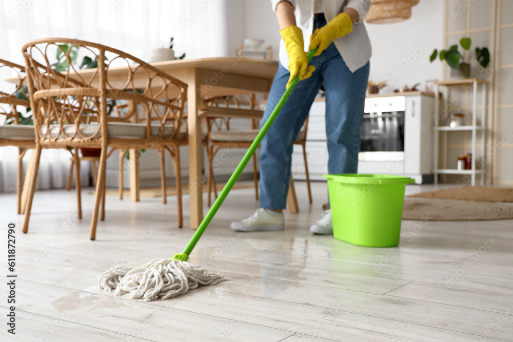 Housewife mopping floor in kitchen