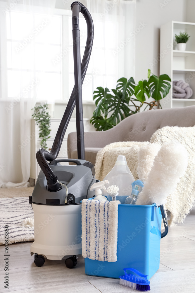 Bucket of cleaning supplies and hoover in living room