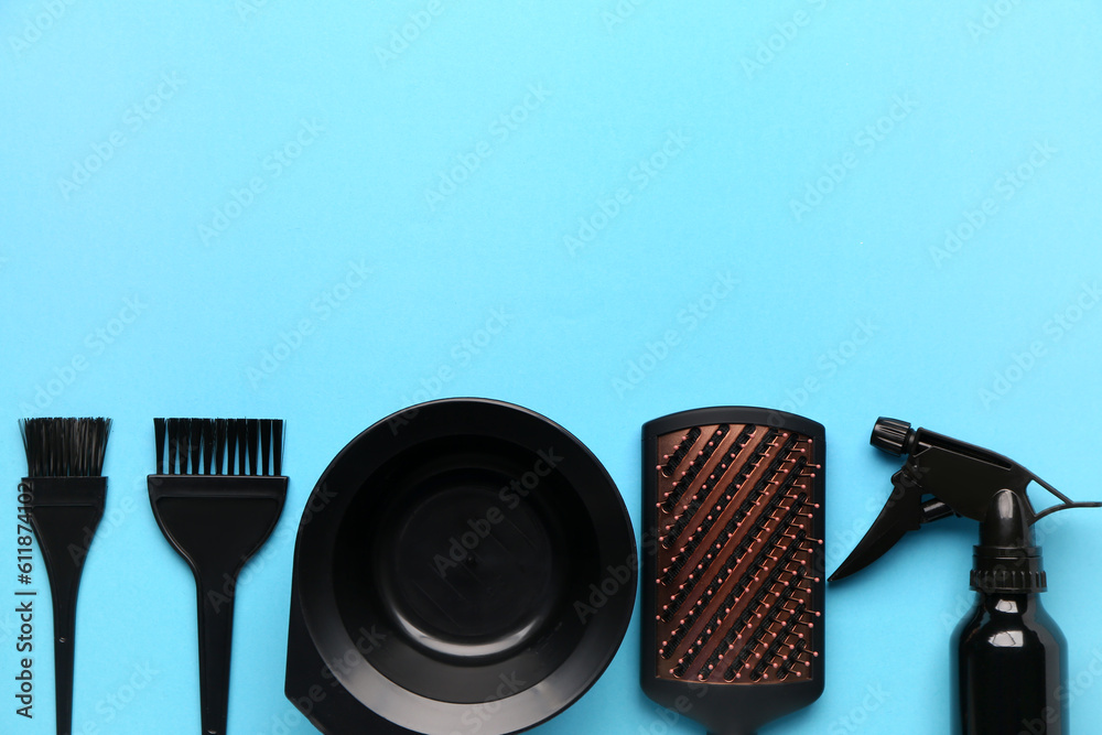 Hairdressers brushes with spray and bowl on blue background