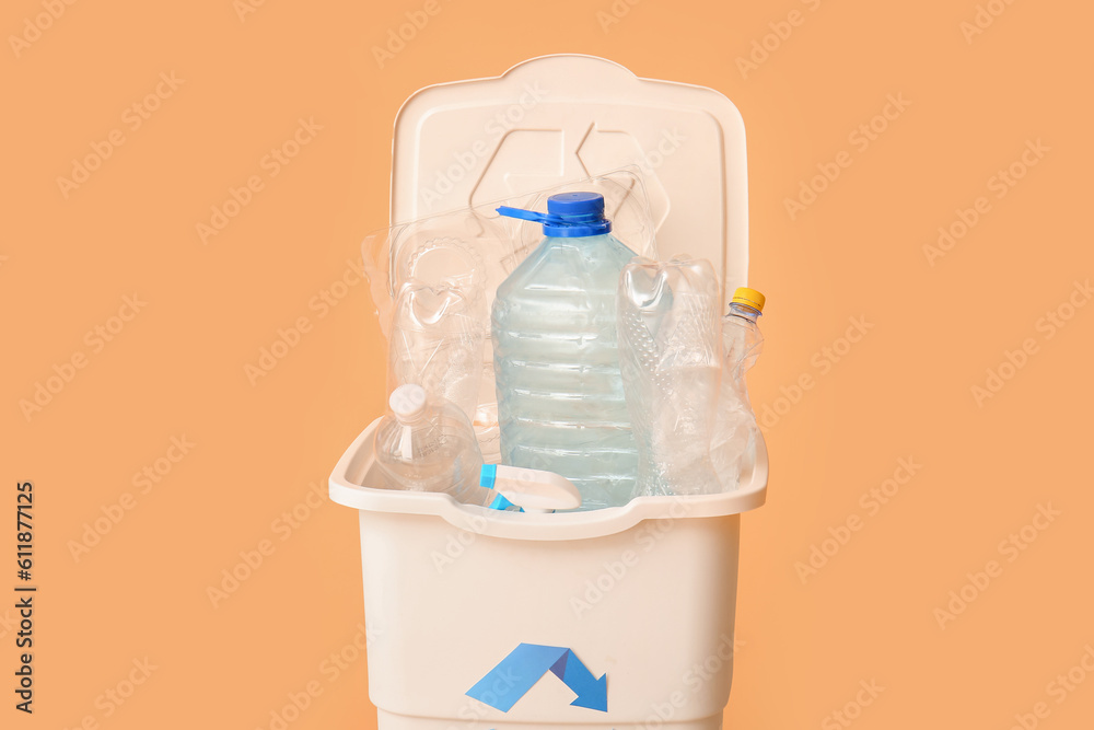 Container for garbage with plastic on beige background. Recycling concept