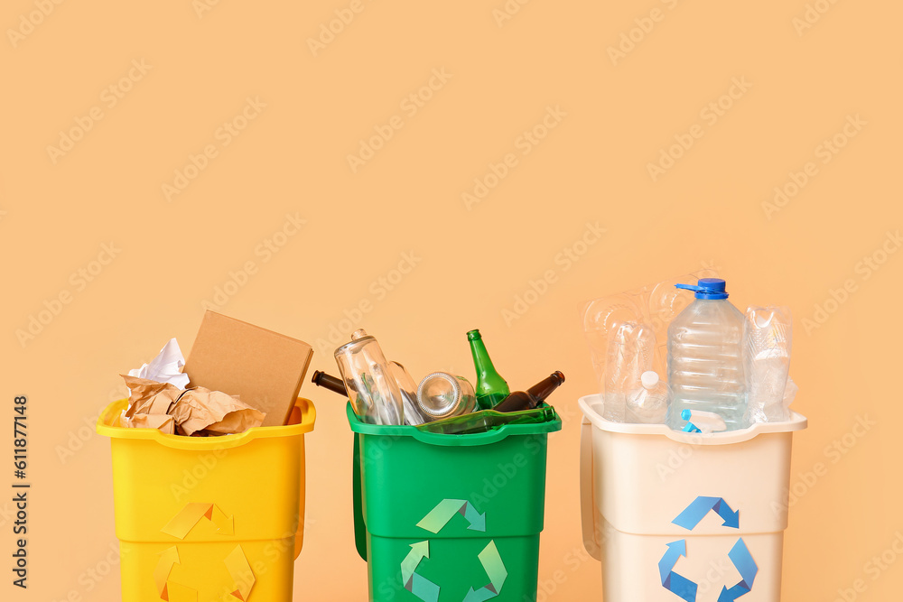 Containers with different types of garbage on beige background. Recycling concept