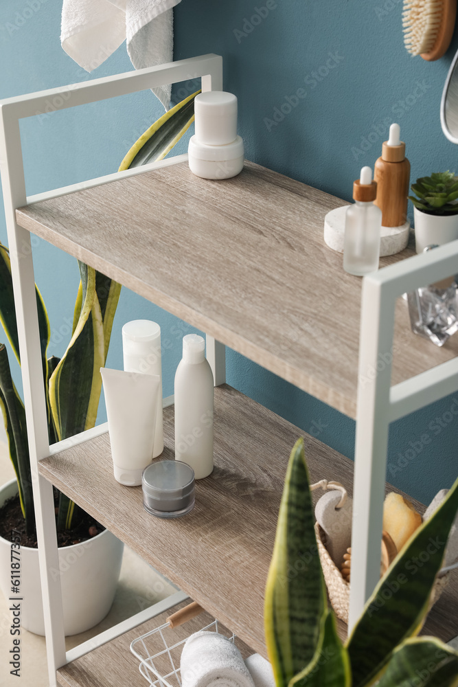 Shelving unit with bath accessories near blue wall, closeup