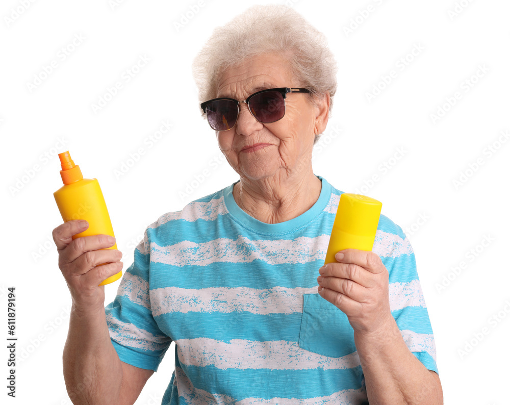 Senior woman with bottles of sunscreen cream on white background