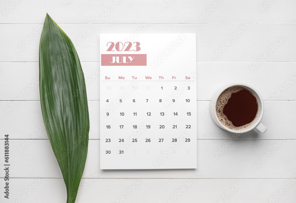 Calendar, tropical leaf and cup of coffee on white wooden background