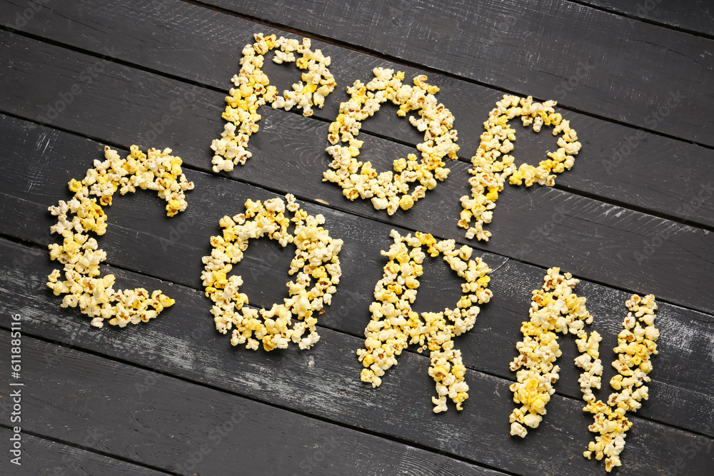 Text POP CORN on dark wooden background