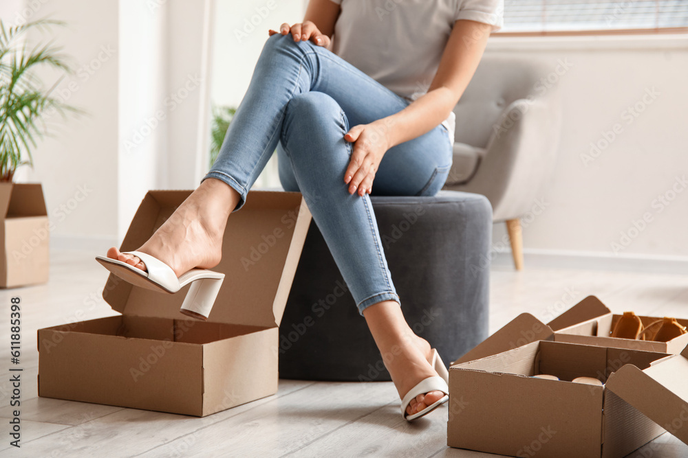 Woman trying on stylish summer shoes in boutique