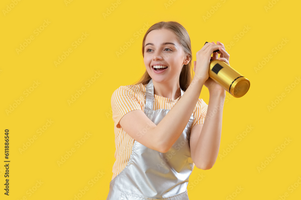 Female hairdresser with spray on yellow background